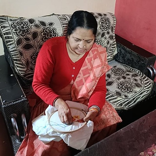 Rekha, an artisan with the PESHAS cluster, at her embroidery