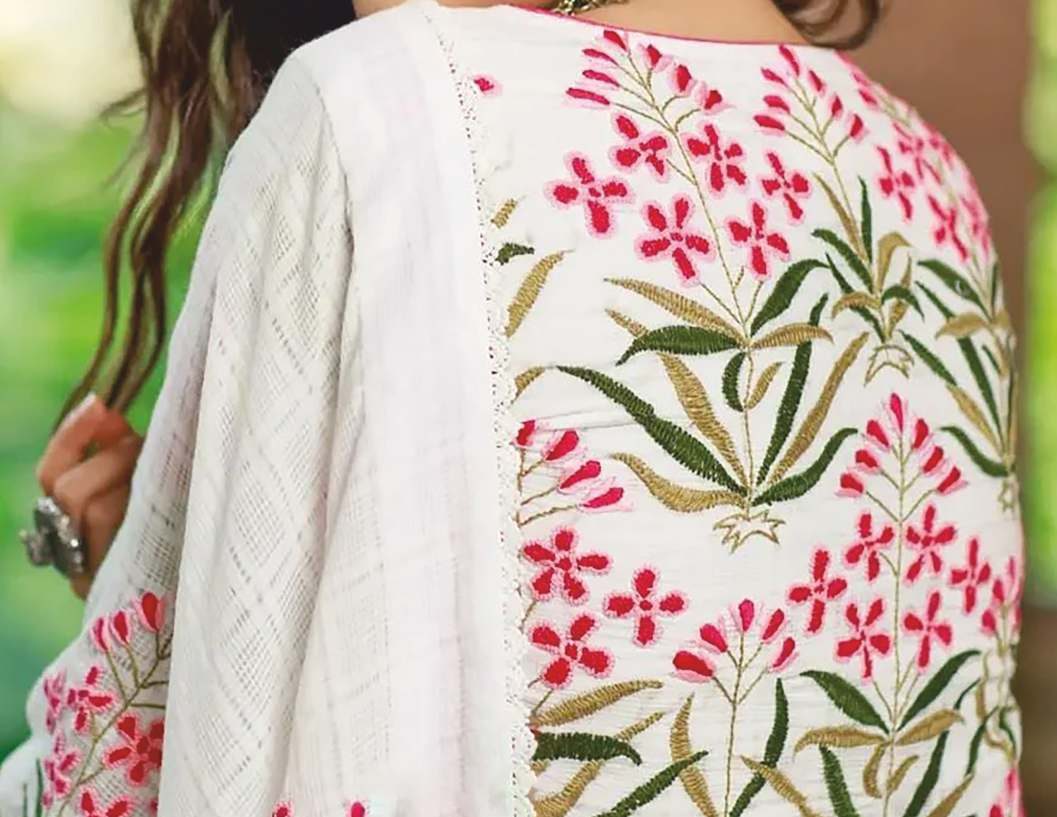 Detail of red and green floral hand embroidery on a white kurta